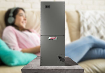 A young woman comfortably listens to music behind a Lennox air handler