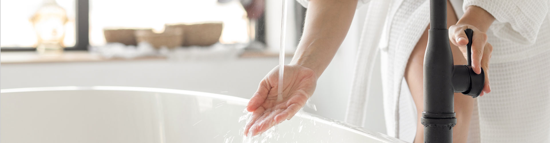 Woman drawing a bath with warm water supplied by a Gas Doctor installed hot water heater